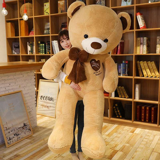 Large teddy bear with bow shown as a statement display plush