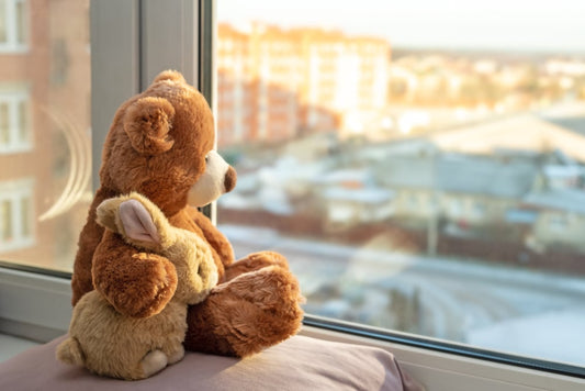 Teddy bear & rabbit on window sill. Adorable stuffed toys gazing out the window, creating a heartwarming scene.