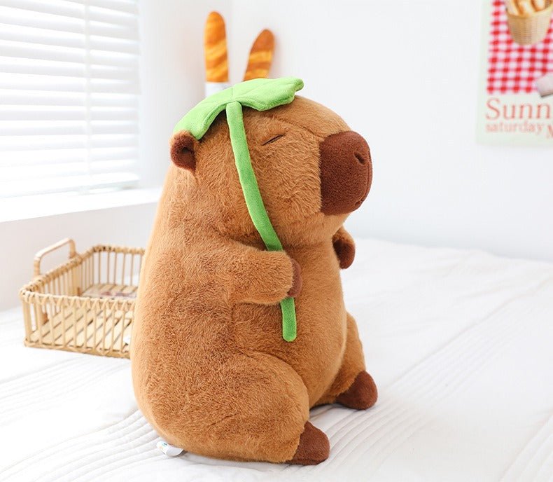 Brown capybara plush toy with green lotus leaf