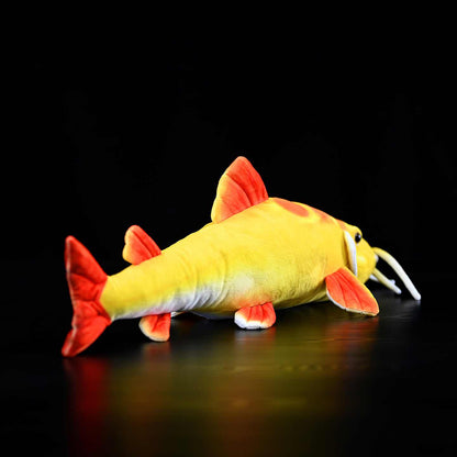 Golden redtail catfish plush toy shown from the side